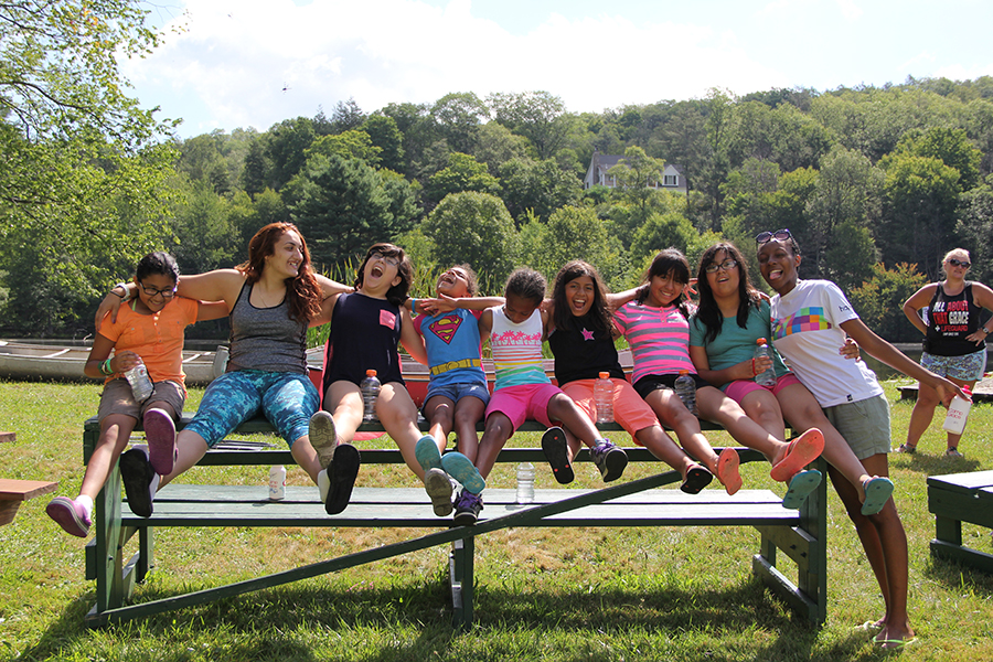 Girls laughing together on a bench at Camp Grace