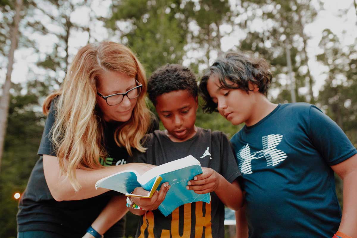 Camp Grace ministry partners reading Bible with campers